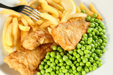 Plate of tasty fried fish and chips with peas, closeup