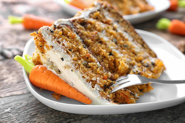 Piece of delicious carrot cake and fork on plate