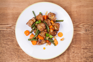 Sauteed liver with vegetables on white plate. View from above, top studio shot