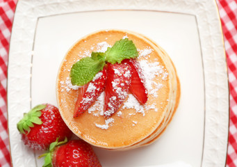 Plate with delicious pancakes on napkin