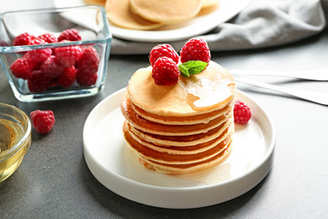 Plate with delicious pancakes on table