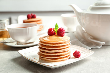 Plate with delicious pancakes on table