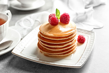 Plate with delicious pancakes on table