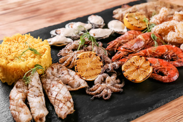 Variety of seafood with rice on slate plate