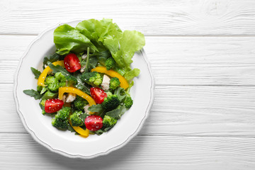 Plate with broccoli salad on wooden background
