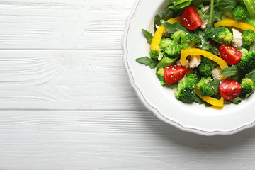 Plate with broccoli salad on wooden background
