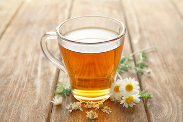 Cup of chamomile tea on wooden table
