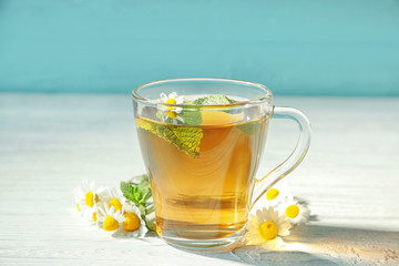 Cup of chamomile tea on wooden table