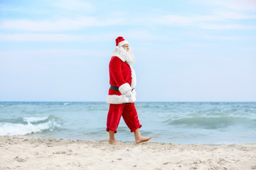 Authentic Santa Claus walking on beach
