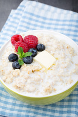 Oatmeal porridge in bowl with berries raspberries and blackberries.
