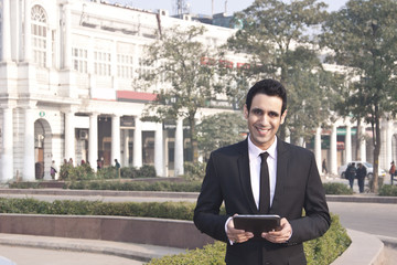 Portrait of a businessman holding a digital tablet , INDIA , DELHI