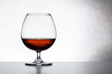 Glass with cognac on white background isolated. Front view. Close up shot. High resolution
