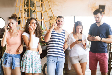 Group of friends using their phones in bar