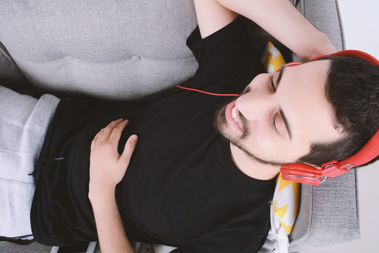 Man listening music on couch.