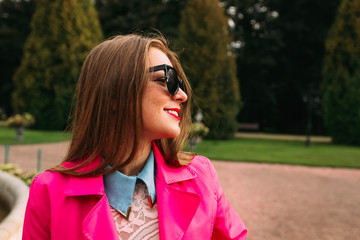 Stylish girl in pink jacket smiling closeup