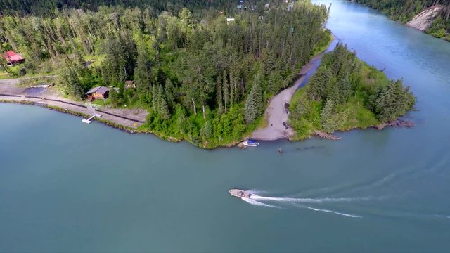 Alaska Kenai River Drone overview of blue river bend with power boat driving up river for salmon fishing in the summer