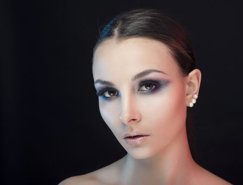 Portrait of a girl with clean skin and bright makeup on black  isolated  background