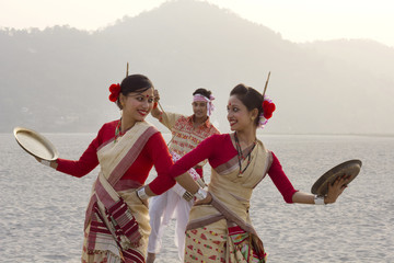 Bihu women dancing with brass plates 