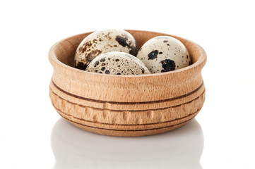 quail eggs in wooden plate isolated on white background