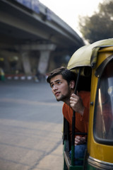 Man looking out of an auto rickshaw 