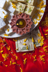 Top view of sweets , diya and currency