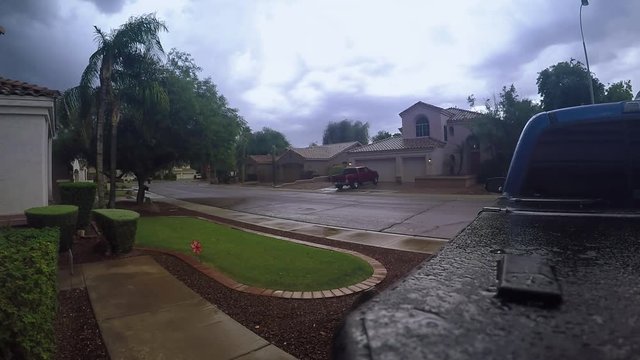An establishing shot of a summer storm over a typical Arizona residential neighborhood in a suburb of Phoenix. Shot at 60fps.  	