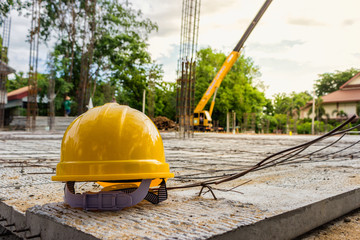 Yellow and white helmets are placed on the wooden table inside the construction area.