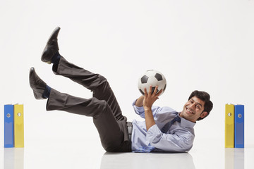 Portrait of smiling businessman playing in goal between files 