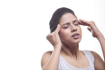 Fototapeta premium Close-up of young woman suffering from headache isolated over white background 