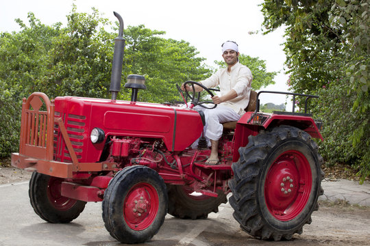 Portrait of a farmer sitting on a tractor smiling