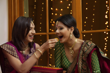 Woman feeding her friend sweets