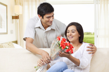 Young man giving flowers to woman 
