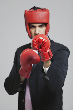 Businessman with boxing gloves in boxing stance 