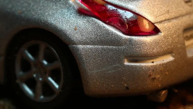 Silver model car melts under heat, extreme close up