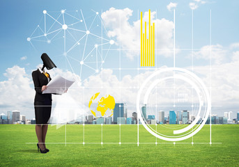 Camera headed woman standing on green grass against modern cityscape