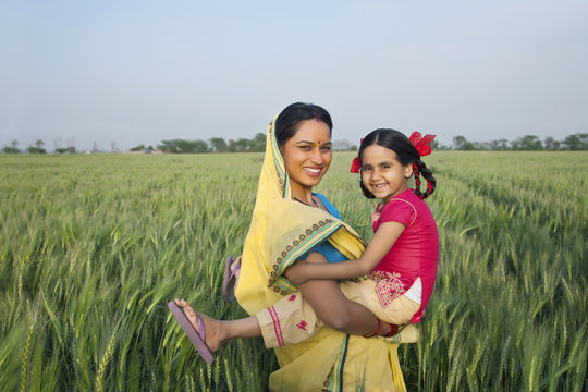 Portrait of a cheerful mother and daughter in the field 