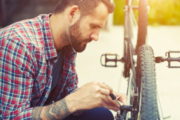 man repairing bike with screwdriver