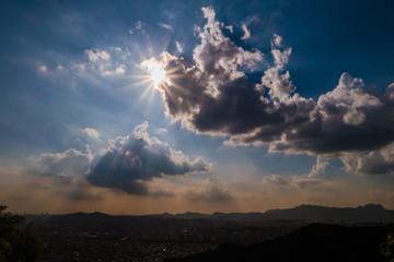 Black clouds and sun in the city center.