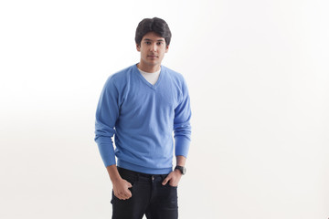 Fototapeta premium Portrait of young man standing with hands in pockets 