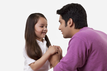 Naklejka premium Father and daughter holding hands over white background 