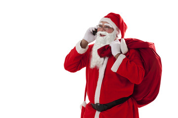 Santa Claus talking on mobile phone while carrying sack over white background 
