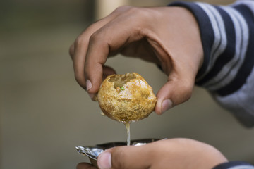 Close-up of man holding panipuri served in a bowl