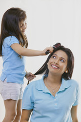 Girl brushing mothers hair