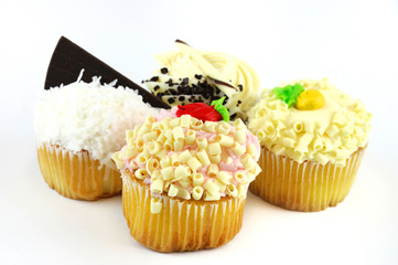 fresh baked muffins with colorful cream on top isolated on white background