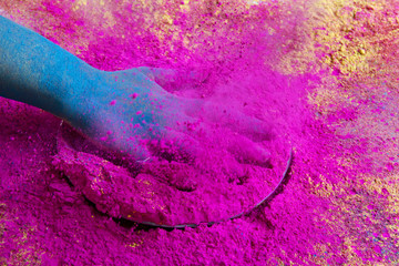 Close-up of hand splashing pink powder paint during Holi festival