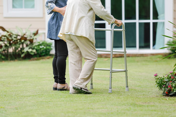 Fototapeta premium Elderly woman exercise walking in backyard with daughter