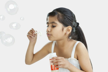 Little girl blowing bubbles