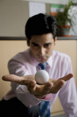 Executive holding a golf ball 