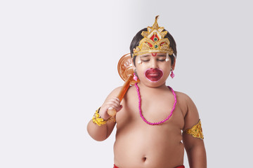 Cute boy dressed as God Hanuman against white background