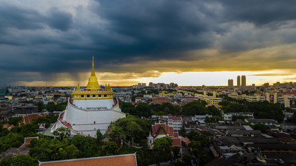  'Golden Mountain '  Wat Saket Ratcha Wora Maha Wihan popular Bangkok tourist attraction , Landmarks of bangkok Thailand . In the rain before , topview